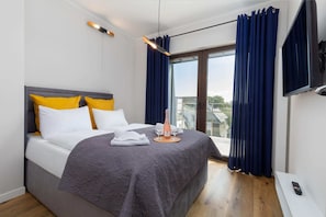 A bedroom with a double bed, gray bedding, and yellow accents, offering a stylish and inviting space.