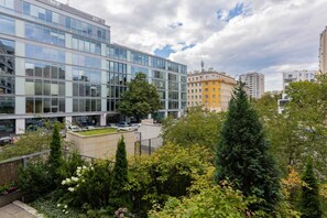 A view from the apartment overlooking a beautifully landscaped green area surrounded by modern architecture.
