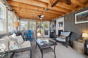 Three seasons porch with additional seating/relaxing areas, opening up to the outdoor shower and private fenced in yard