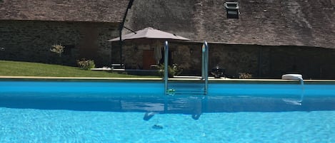 View across the pool towards the back of the gîte. 