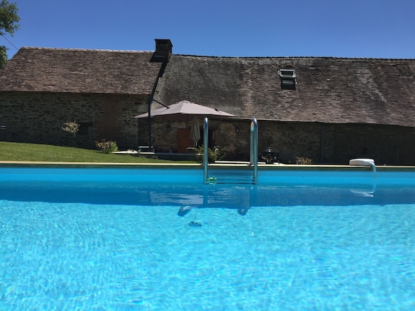 View across the pool towards the back of the gîte. 