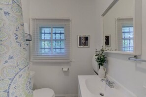 Beaming shower and bathroom with new vanity, towels, and soap essentials