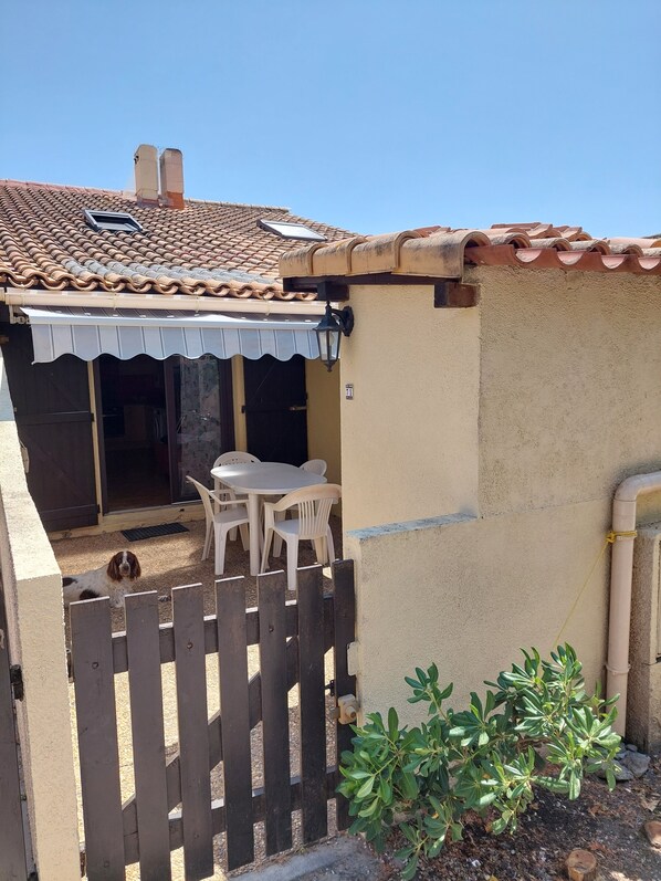 cour avec salon de jardin store et  cabanon pour affaires de plage 