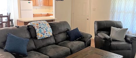 Entry way, kitchen on the right, living room on the left. Comfy couch and chair