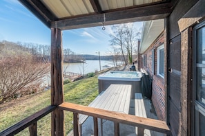 Soak in the private hot tub with breathtaking lake views!