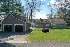 View from Spellman Point Road toward the lake. Game building (former garage) on the left. Ping pong, full size pool table, and EV charger in here!