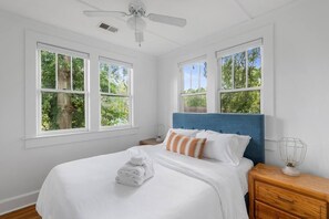 The bedroom has a queen-sized platform bed, all cotton linens, and tree top views.