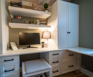 Remote work space.  Tall cabinet is filled with games and puzzles.