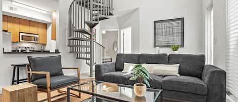 Living room with sofa, smart tv and high ceilings