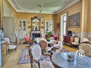 NIVEAU 0 : Salon séjour 62m² avec nombreux fauteuils, canapés, tables, jeu d'échec, jeux de société, piano électrique, télévision – H53G018763 - Château de la Roche – Ahuillé – Gîtes de France Mayenne
