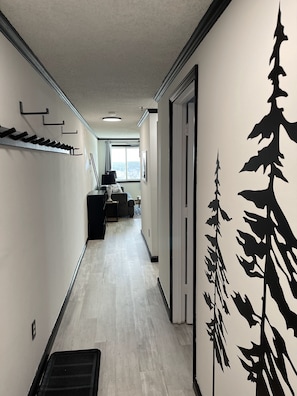 Entryway with coat hooks, two snowboard racks, two ski hooks and boot mats.