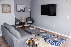 There is a sofa and plenty of seating in the living area. 