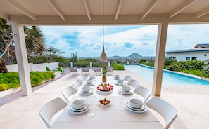 Large outdoor dining table next to the pool
