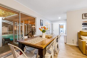Our rustic-style dining table seats 8 and has a view of the oak-filled backyard and screened-in heated pool