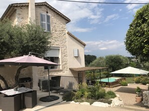 Terrasse du haut avec salon de jardin, parasol et plancha