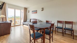 A bright and airy space with a dining table and comfortable seating, perfect for enjoying meals or unwinding after a busy day.