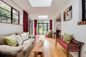 Living Room: Bright and airy space with garden views, perfect for relaxation and gatherings!