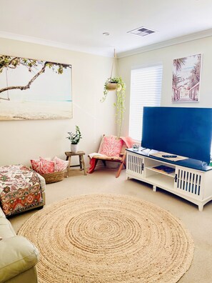 Family living room with smart tv and leather sofas set in a coastal style