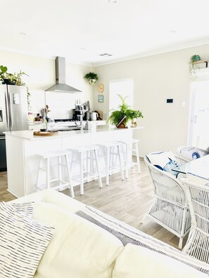 Spacious open plan living and dining room with a coastal theme.