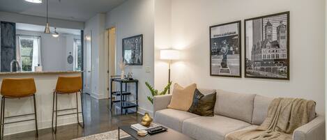 Unit 1: Open concept living room complete with designer furnishings and smart TV.