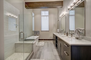 The master bathroom includes dual vanities, bathtub, an oversized step-in glass shower, and closet space.