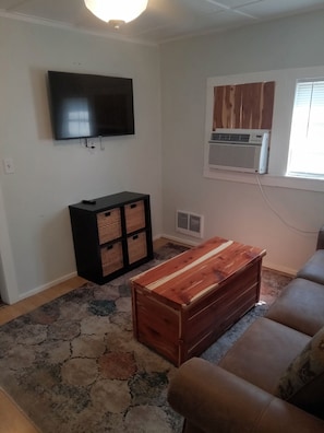 Livingroom has Smart TV and a Queen sleeper extra bedding in chest