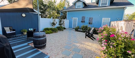 Private entry and small private yard with deck, BBQ,  and lounge seating