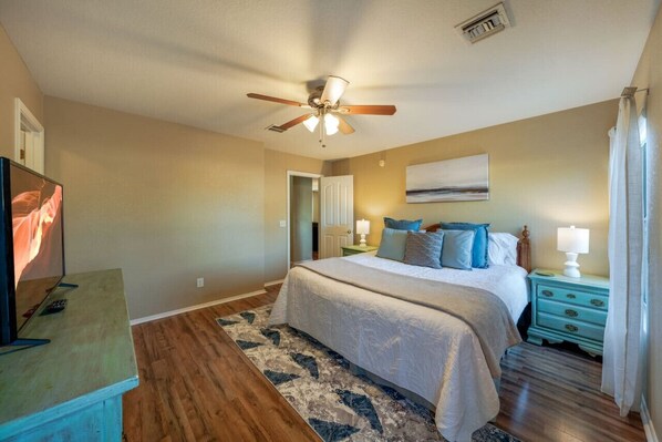 Primary bedroom with king-size bed, smart TV, en-suite bathroom, and walk-in closet