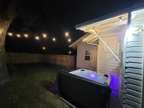 Night view of backyard and hot tub