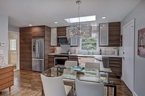 Simple glass dining table and fully equipped kitchen area