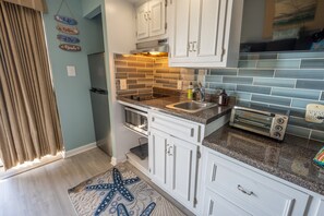 - Cook up something delicious in this elegant beachside kitchenette with modern touches - Sleek countertops, a glass tile backsplash, & under cabinet lighting - Compact yet fully equipped, perfect for morning coffee or a quick bite before the beach