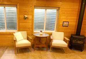 Two cozy chairs next to entrance and fireplace