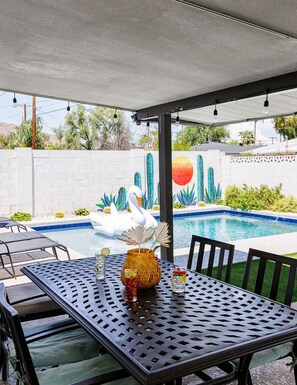 Backyard with pool, outside dining table, lounge chairs, BBQ grill, and bonfire pit.