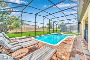 Relax and soak up the sun by the private screened pool, complete with cozy lounge chairs.