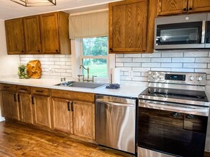 Renovated kitchen with a deep sink, stainless steel appliances and more.