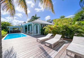 Luxury Caribbean villa with wooden terrace, tropical garden and exquisite ambience