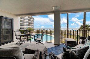 Private balcony with pool, beach, and ocean views.
