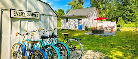 [Patio, Backyard] Lakeside bliss: Where cruiser bikes, firepit, and grill meet for the perfect retreat.