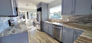 Custom kitchen featuring granite countertops, stainless-steel appliances. 