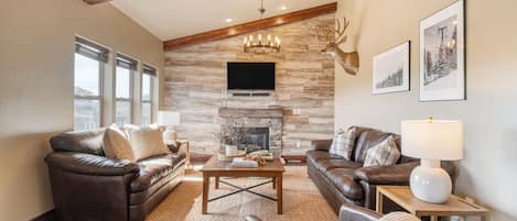 Living room features a fireplace, TV, and two sofas.