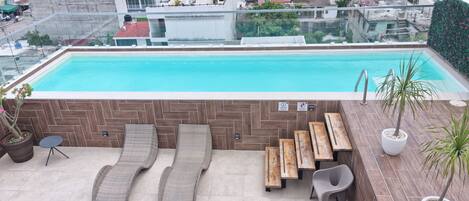 pool-outside-view-city-top-building-beach-chairs