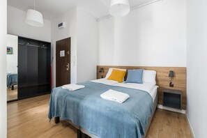 Another angle of the bedroom, showcasing its spacious layout, minimalist style, and warm lighting.
