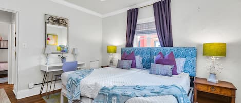 This beautiful Master bedroom has a king-sized bed (two twins together), patterned upholstered headboards, updated furnishings and a personal desk and chair for remote working. The room is lovely and bright with colorful tones and Palm Beachy Feel.
