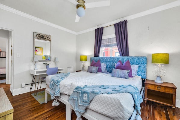 This beautiful Master bedroom has a king-sized bed (two twins together), patterned upholstered headboards, updated furnishings and a personal desk and chair for remote working. The room is lovely and bright with colorful tones and Palm Beachy Feel.