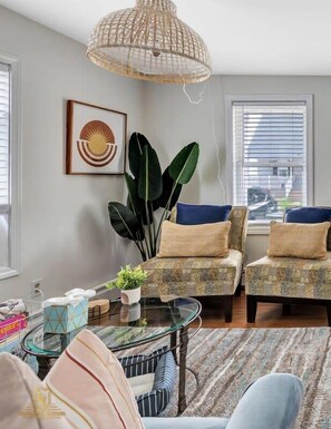 our inviting living room awaits, bathed in soft light and adorned with touches of homey charm