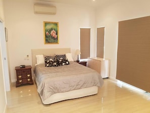 Main bedroom with queen bed overlooking internal courtyard and fish ponds