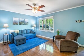 Spacious living area with lounge seating, tv, and picture window 