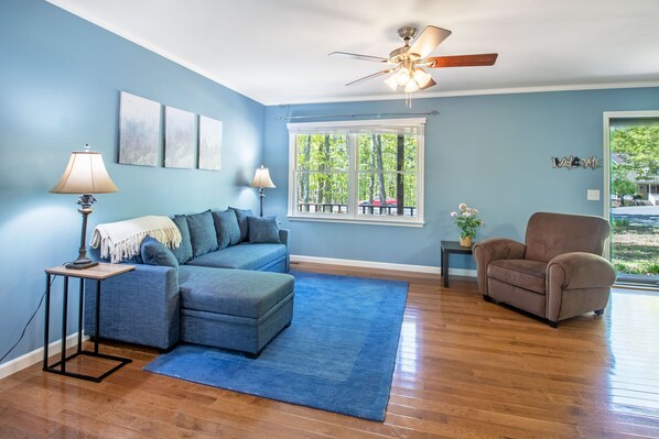 Spacious living area with lounge seating, tv, and picture window 