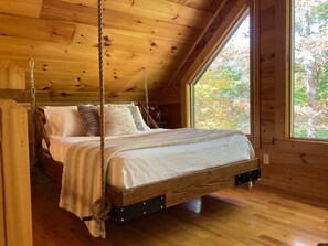 In the loft we have a hanging Queen sized bed overlooking the trees outside!