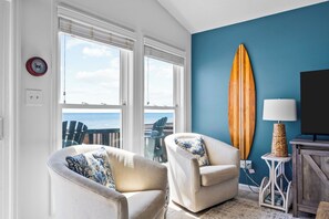 The living room is a cozy place to spend time with friends and family while taking in the sweeping oceanfront views.